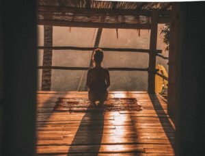 Woman sitting in peaceful meditation pose demonstrating proper mindfulness technique for beginners